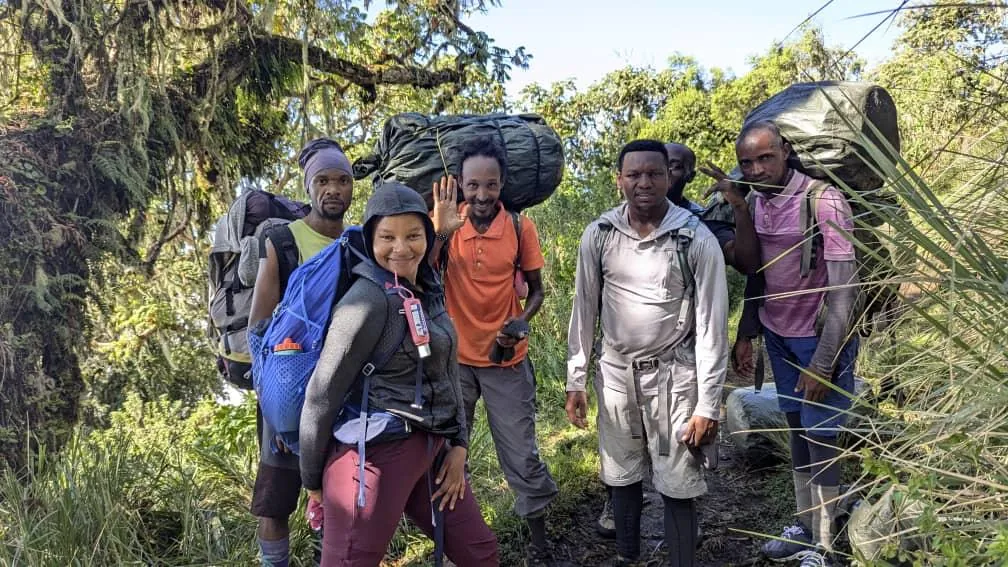 Trekkers resting on the forested lower slopes of Mount Meru